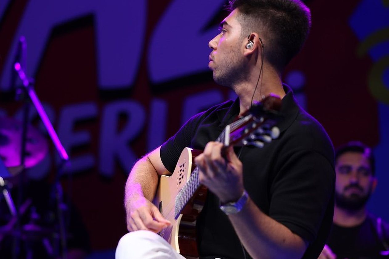 Gitar eğitmeni Eray Polat sahnede klasik gitar çalarken